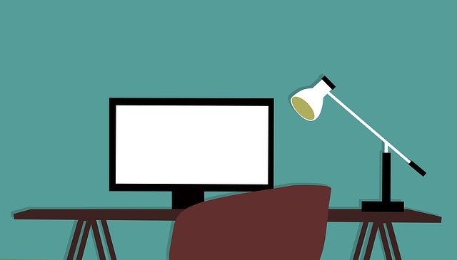 kreslené pracovní místo s počítačovou obrazovkou a lampou